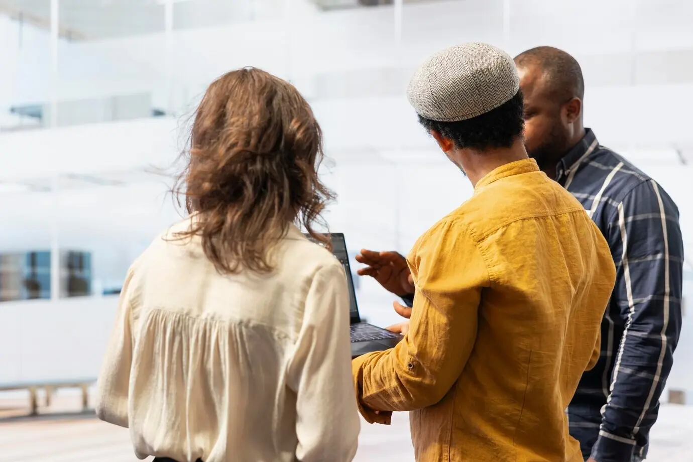 Деловые специалисты оценивают чертежи объектов недвижимости на ноутбуке.